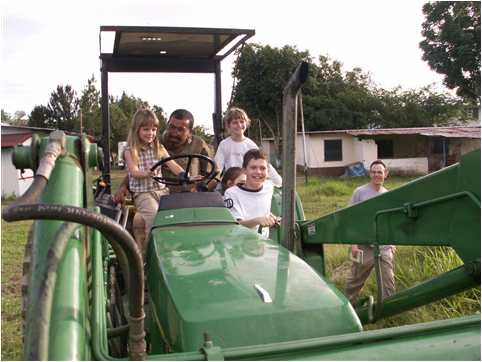 IRR staff kids riding tractor at Colgransa in Venezuela