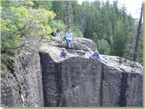 Fred Adams and others watching rappellers from opposite cliff ledge