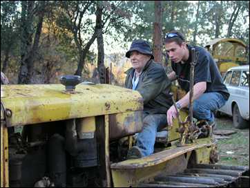 Celian teaching grandson Daniel to drive Caterpillar tractor