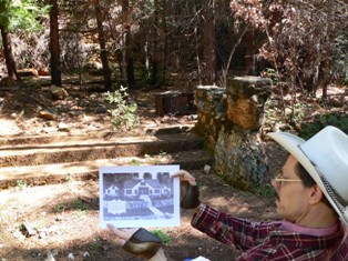 Fred Adams holding photo of Deer View lodge near steps