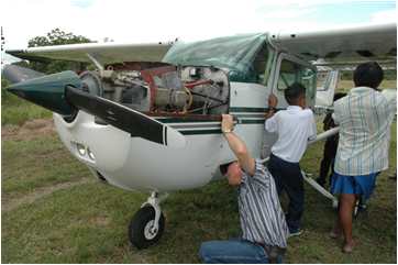 Bob Norton inspecting worn-out mission plane engine