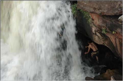 Mission volunteers going under waterfall in Venezuela