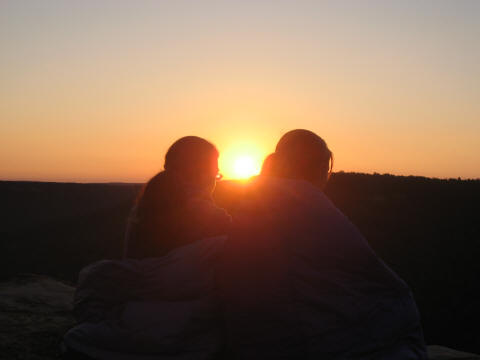 Emily Caza and Ashley bundled up watching sunrise from Stone Door bluffs