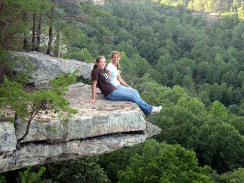 Emily and Ashley sitting on overhanging ledge