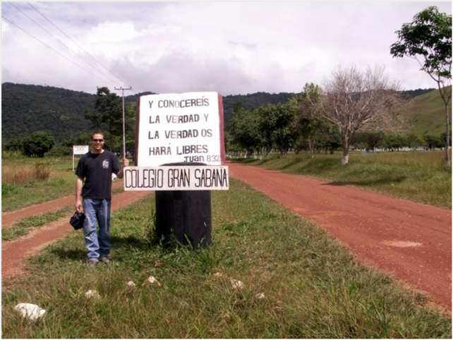 Daniel Adams by Colegio Gran Sabana sign