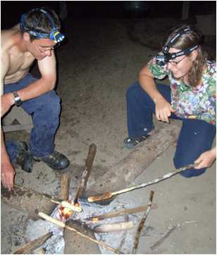 Daniel Adams and Corrie Sample make "Cowboy Biscuits" over coals in Aripichi, Venezuela