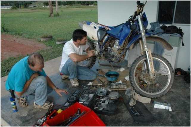 Bob Norton & Dr. Brent Hildebrand rebuilding dirt bike