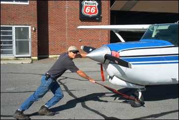 Daniel Adams pushing plane in Frenchville, Maine
