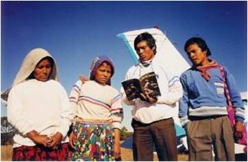 Huichol people study literature brought by mission plane
